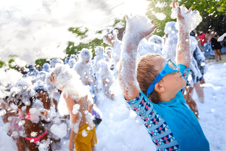 Kids playing in a foam party during CF Fitness summer program